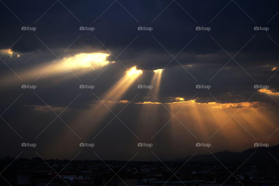 Breaking Through the Shackles. Rays of sun breaking through the clouds in Islamabad, Pakistan.