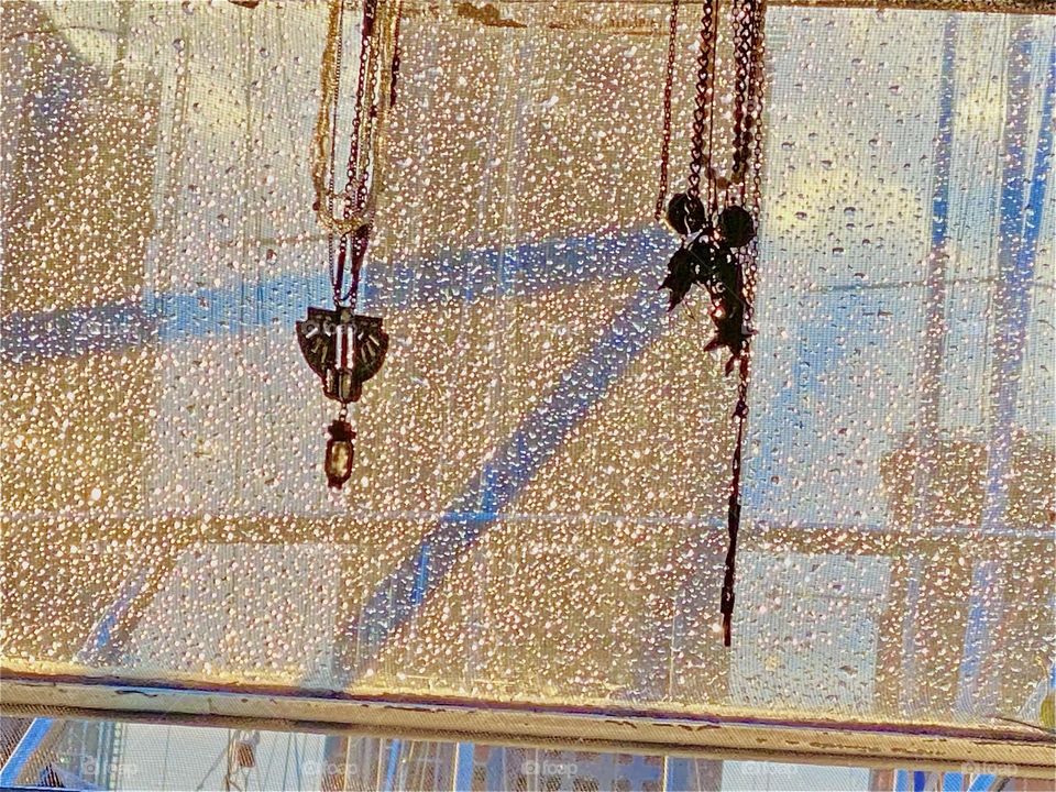 The sunlight shining on the front window of “Salvation”, our “1969 Luhrs” cabin cruiser is causing the front railing to cast shadows on it as well. But what looks like a see through glittery curtain is in fact raindrops. 2023. Hypnotic Productions