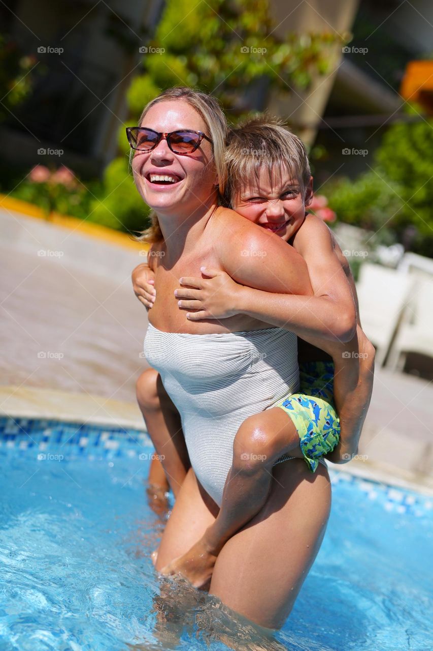 beautiful mom and son, happy.  laugh, rejoice in the pool, spend time together, happy family