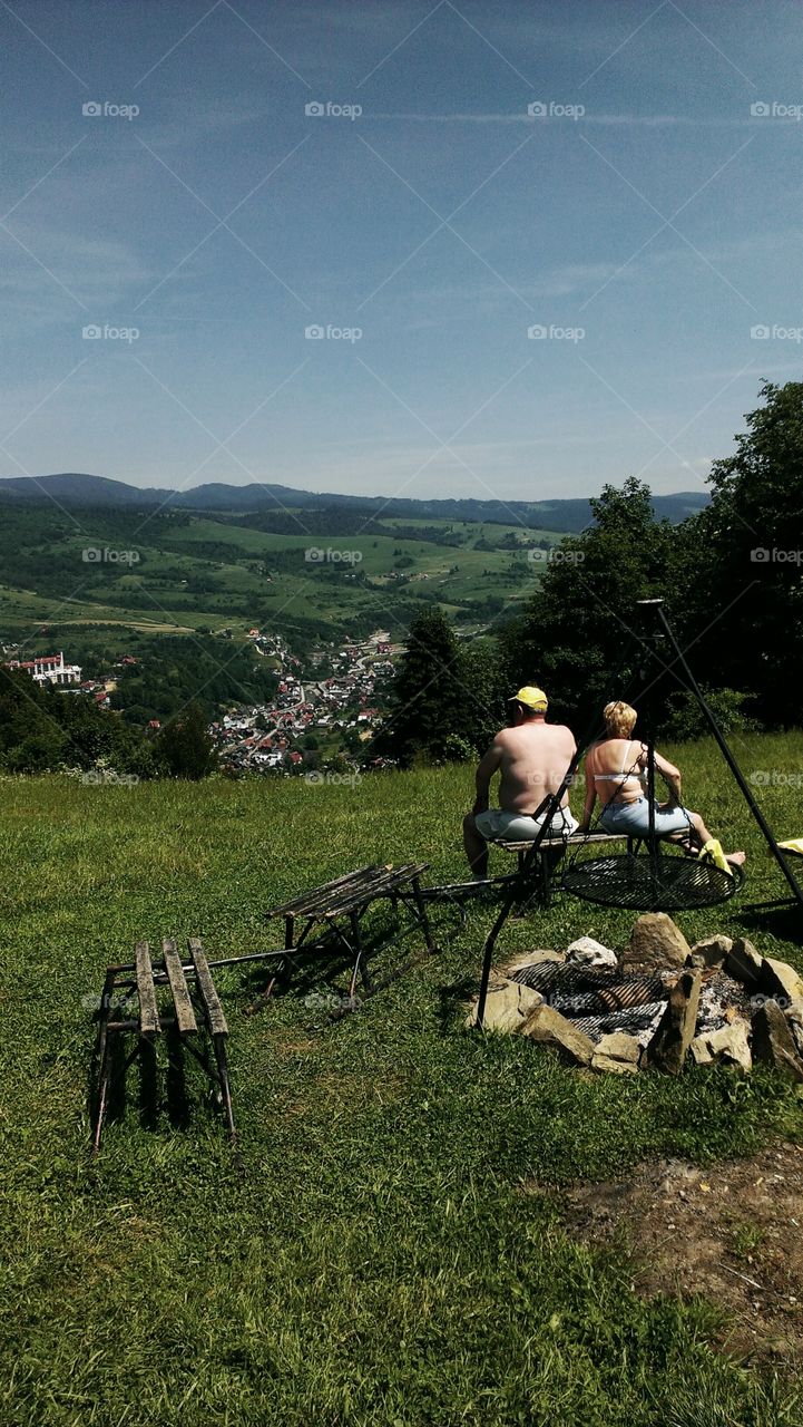 Old couple siting on bench looking at beautiful view