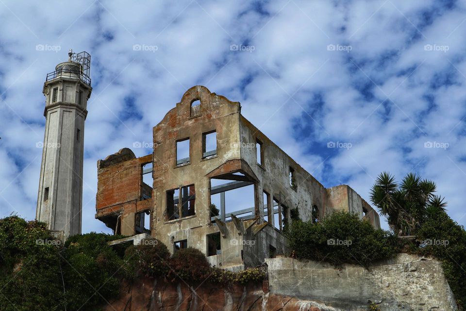 The warden’s house on Alcatraz Island in San Francisco Bay against a blue sky with cotton ball clouds 