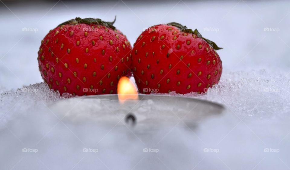 Strawberry with candle light on snow