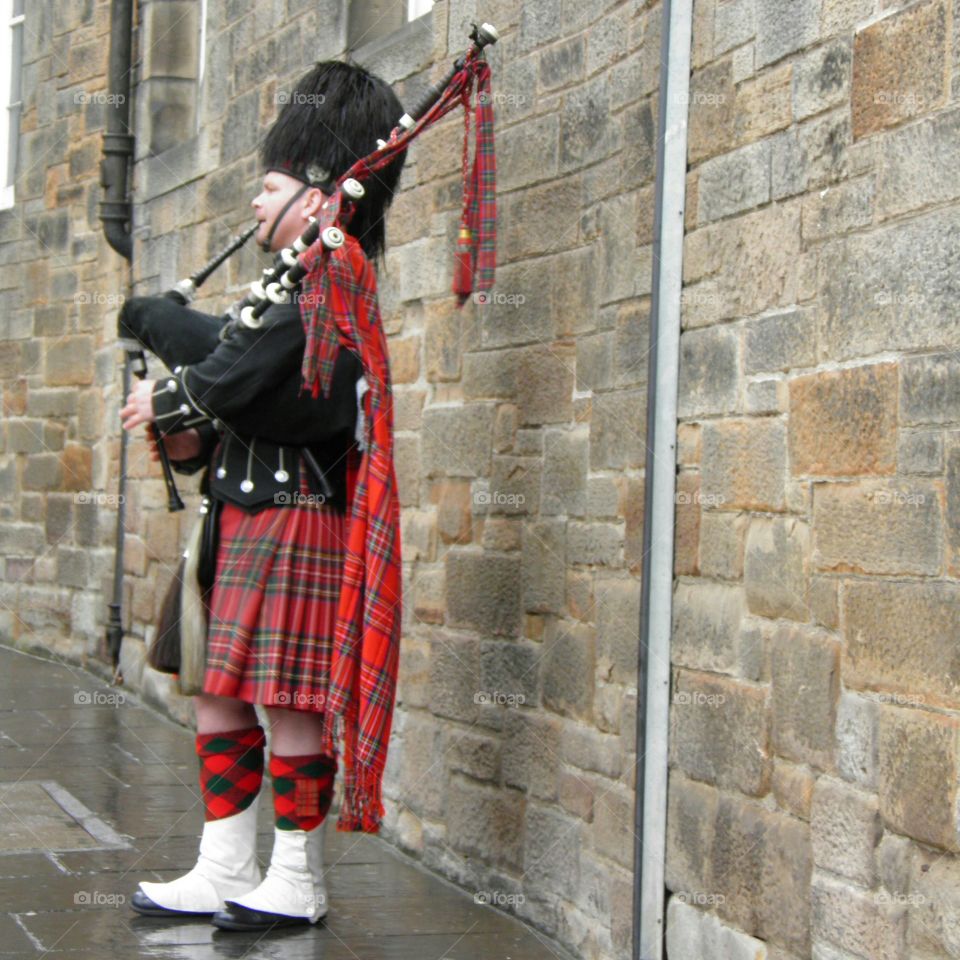 Un écossais jouant de la cornemuse en kilt
