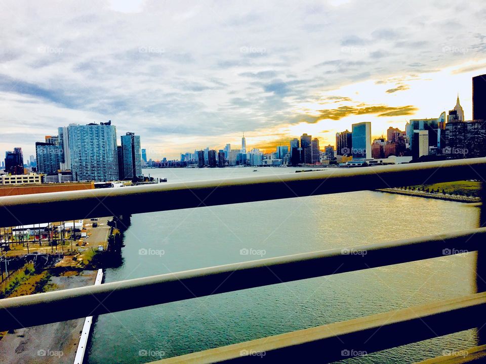 The Manhattan skyline at the horizon to the right side of the East River at Newtown Creek, LIC, Queens, NY and some Long Island City buildings to the left side of the shore. Photo was taken from the Pulaski Bridge in 2019. Hypnotic Productions