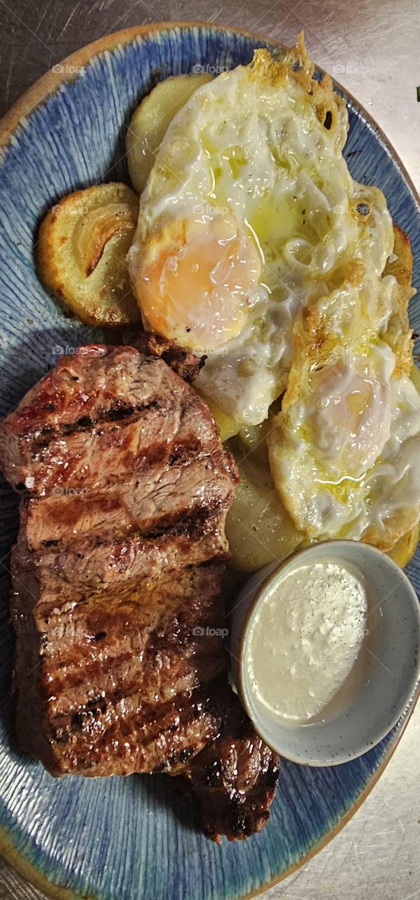 Entrecot al punto al roquefort con patata panadera y huevos fritos