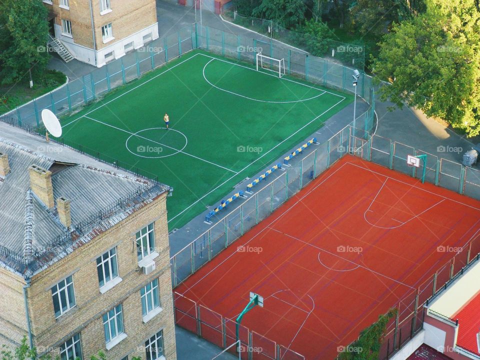 football stadium and tennis court in the courtyard of residential buildings