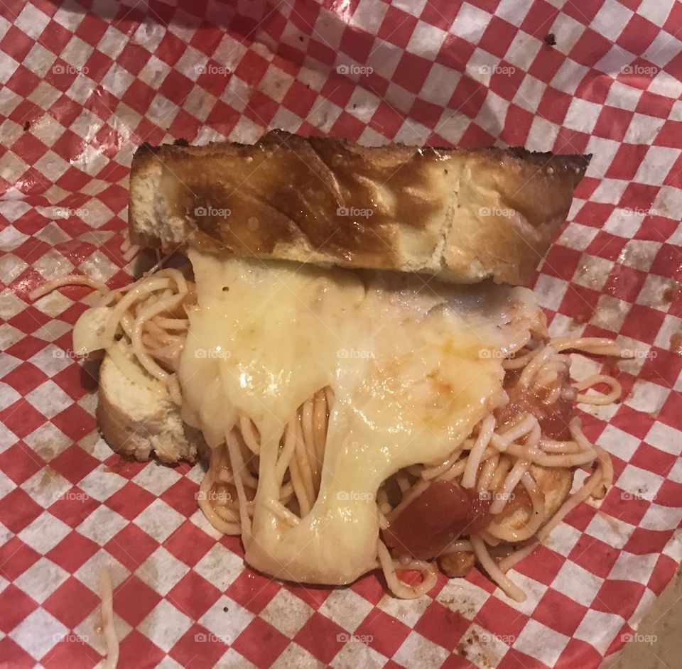 Spaghetti and cheese sandwich on a red and white checkered background 