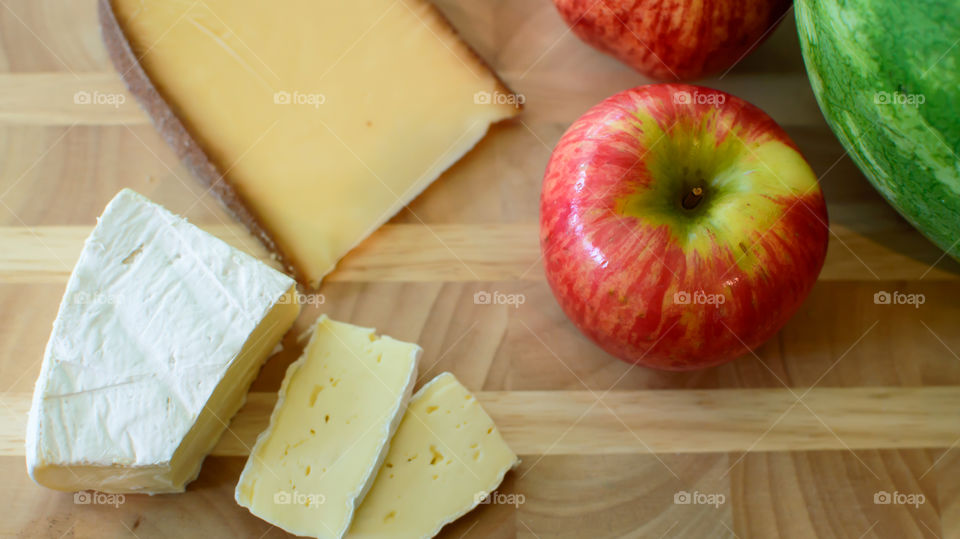 Apple on wood table with sliced cheese healthy lifestyle wine and cheese with fruit plate conceptual image 