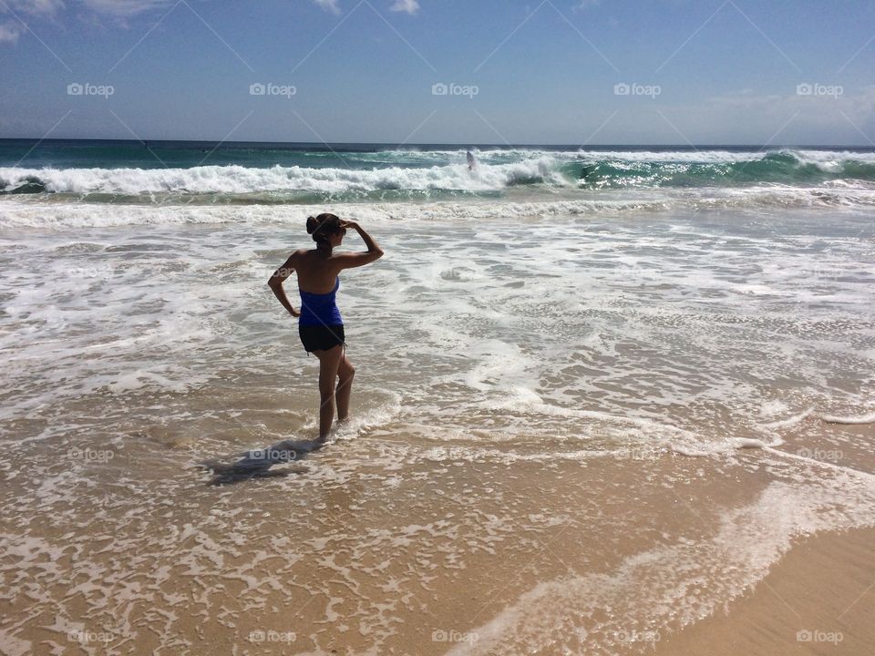 Bathing beauty ankle deep in Bali ocean waters