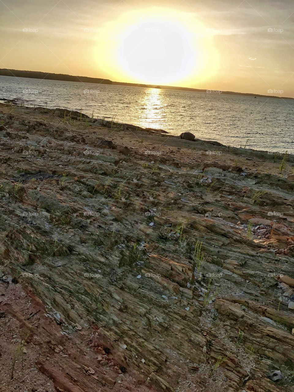 Sunset on the lake and rocky shore 