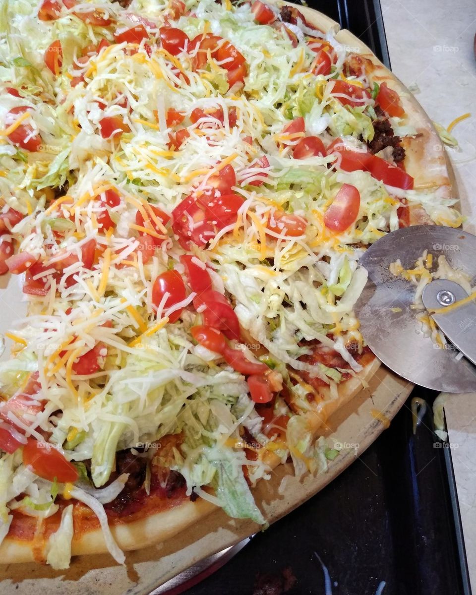 A homemade taco pizza with a homemade crust that a friends made for her granddaughter's birthday.