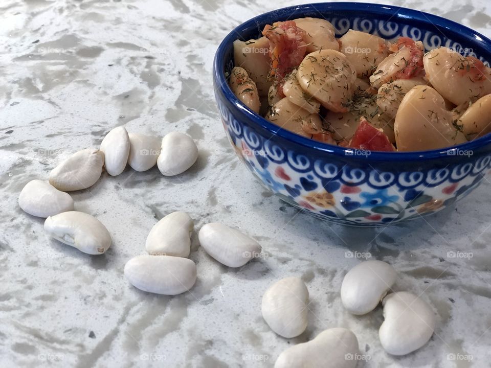 A bowl of Instant Pot Lima bean, tomato, and dill recipe in a Polish pottery bowl.