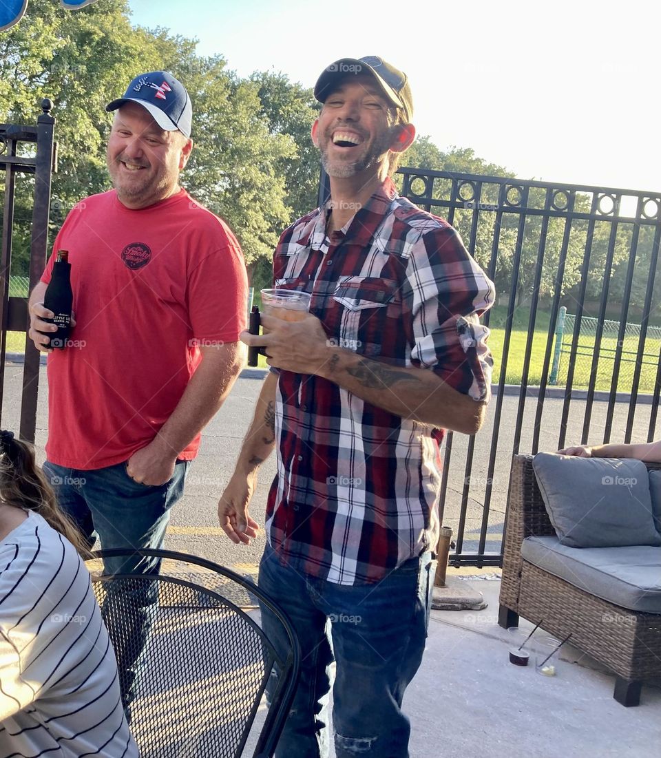 Guys and friends laughing at a party 