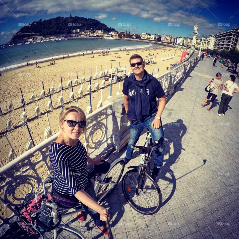 A couple riding a bike in San Sebastian, Spain