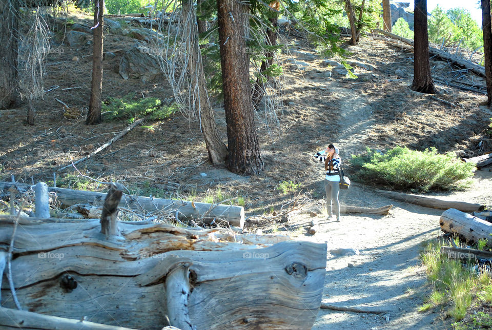 Woman hiking carrying a bag of camera