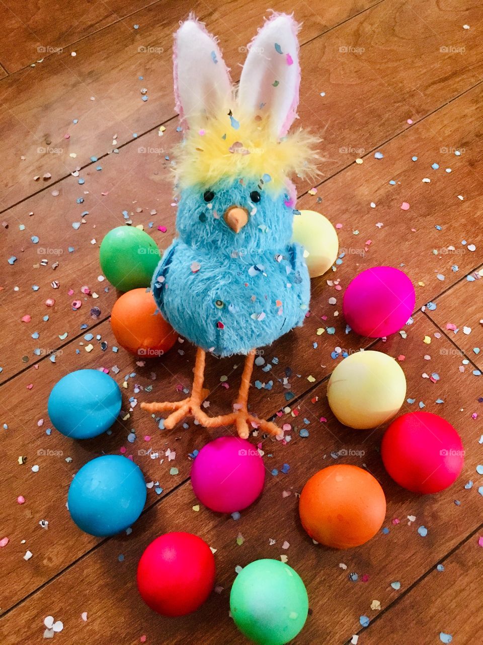 Bunny chick with colorful Easter eggs and confetti 