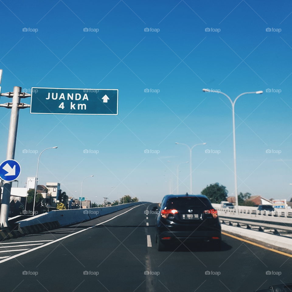 A car is going to Juanda International Airport with the blue clear sky