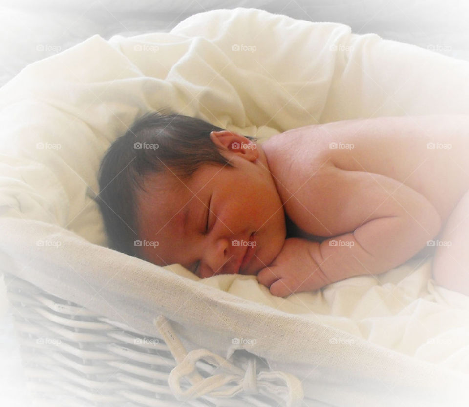 Newborn in basket. Tiny newborn smirking