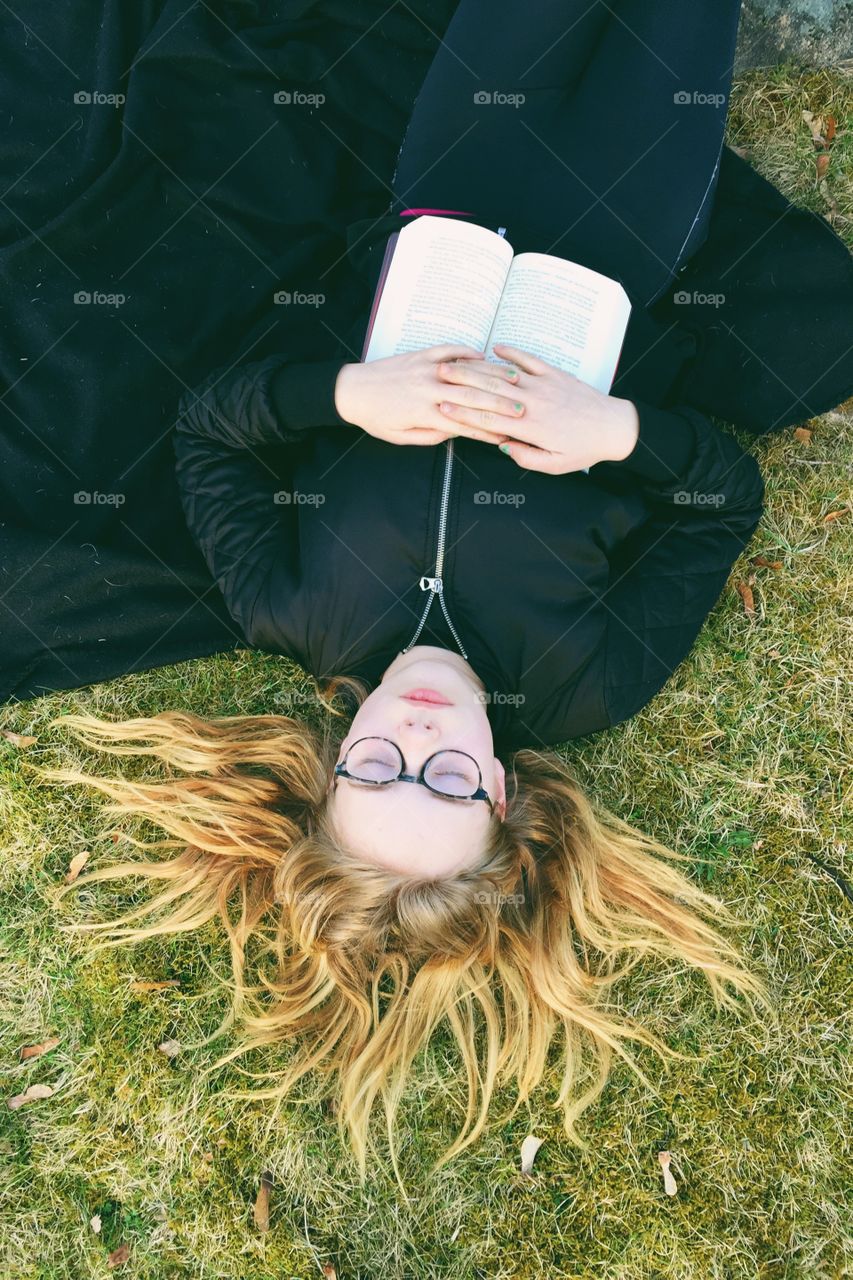 Woman sleeping on field with book