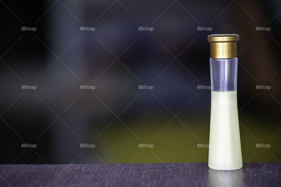 Small bottle shower gel on a wooden table The background blurry.