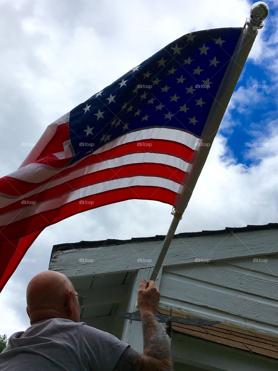 Hubby puts flag🇺🇸in bracket as I hold ladder
