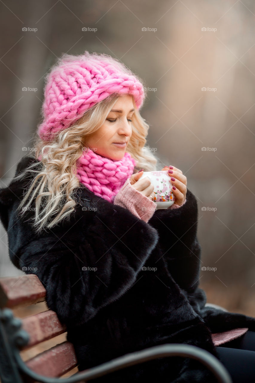 Outdoor Portrait of blonde woman in pink crochet accessories 