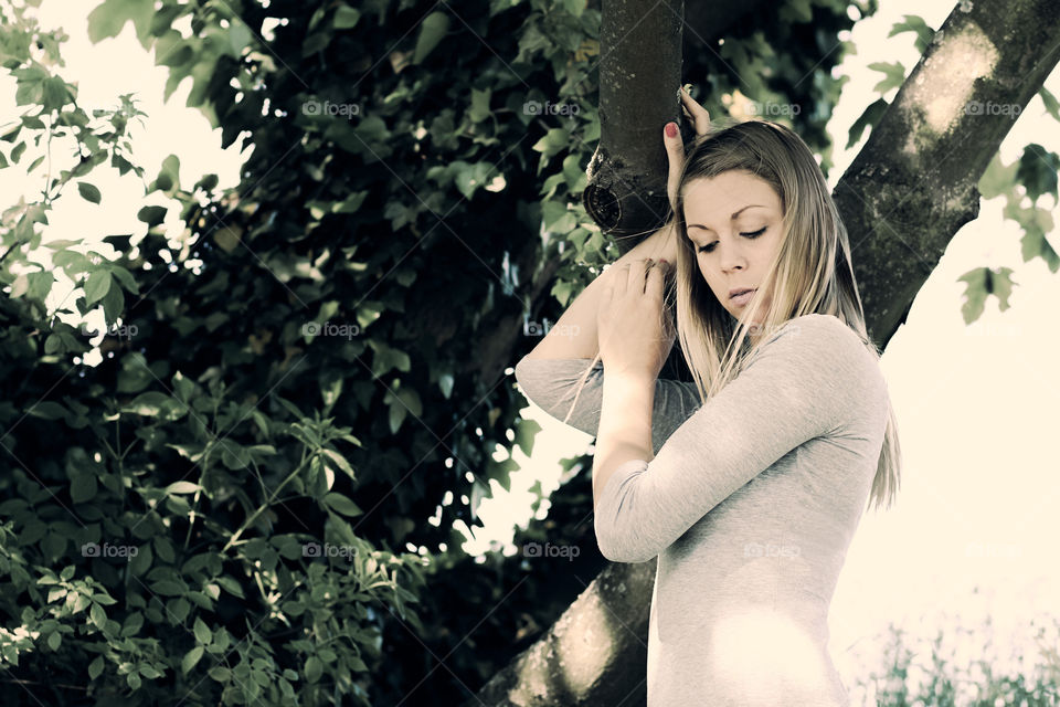 Young woman posing near tree