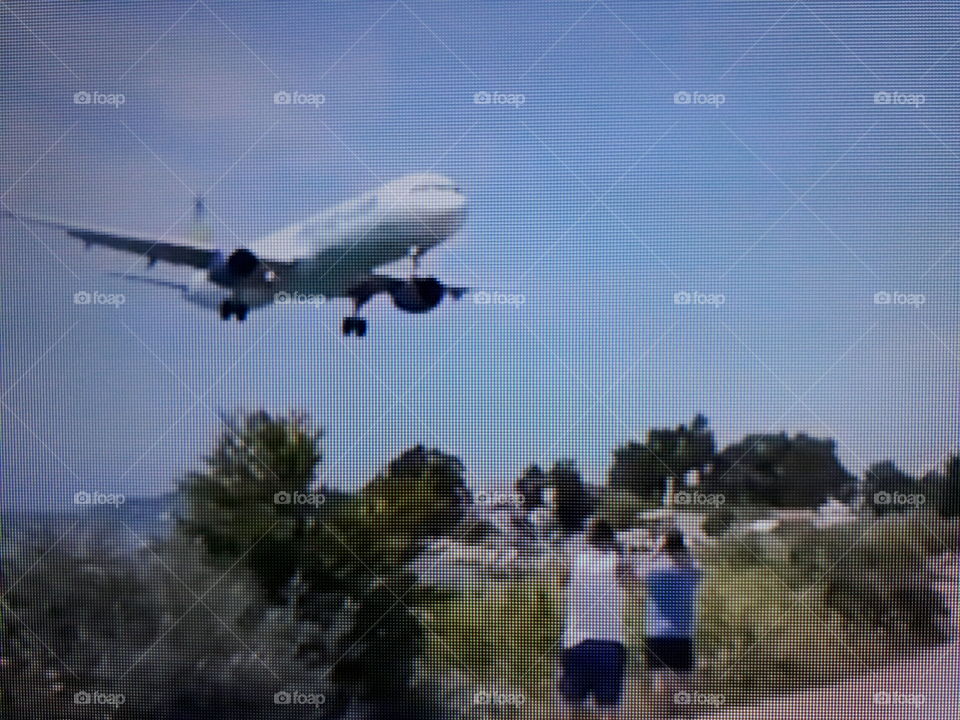 A large plane preparing to land at one of the most dangerous airports in the world crowded with tourists