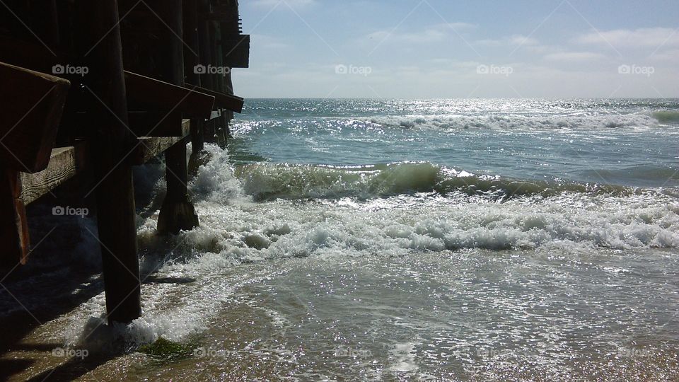 Beach breakers surge against the pilings of Crystal Pier, Pacific Beach, San Diego, CA