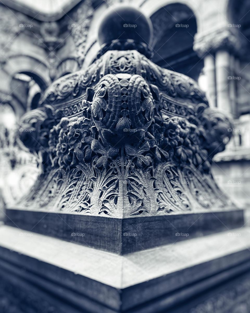 Black and white photography of a Capital on a Column taken at very close proximity 