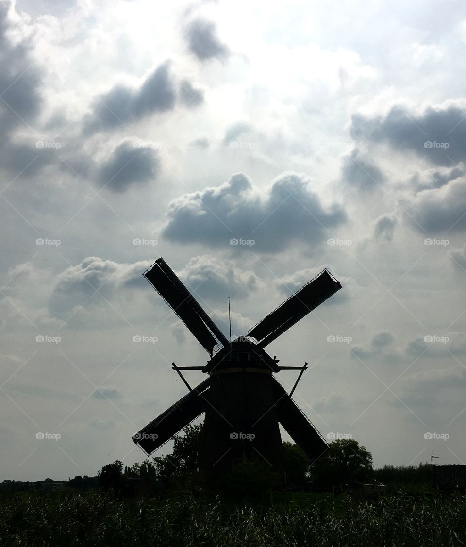 Windmill silhouette with clouds and beautiful light