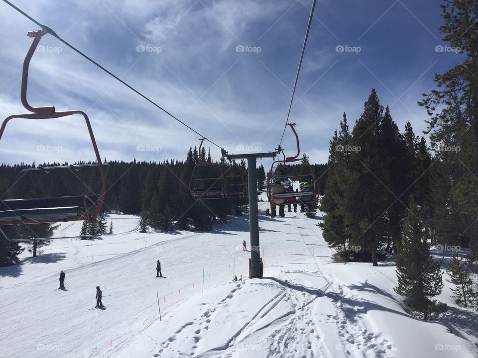 Chairlift bringing people up ski slopes