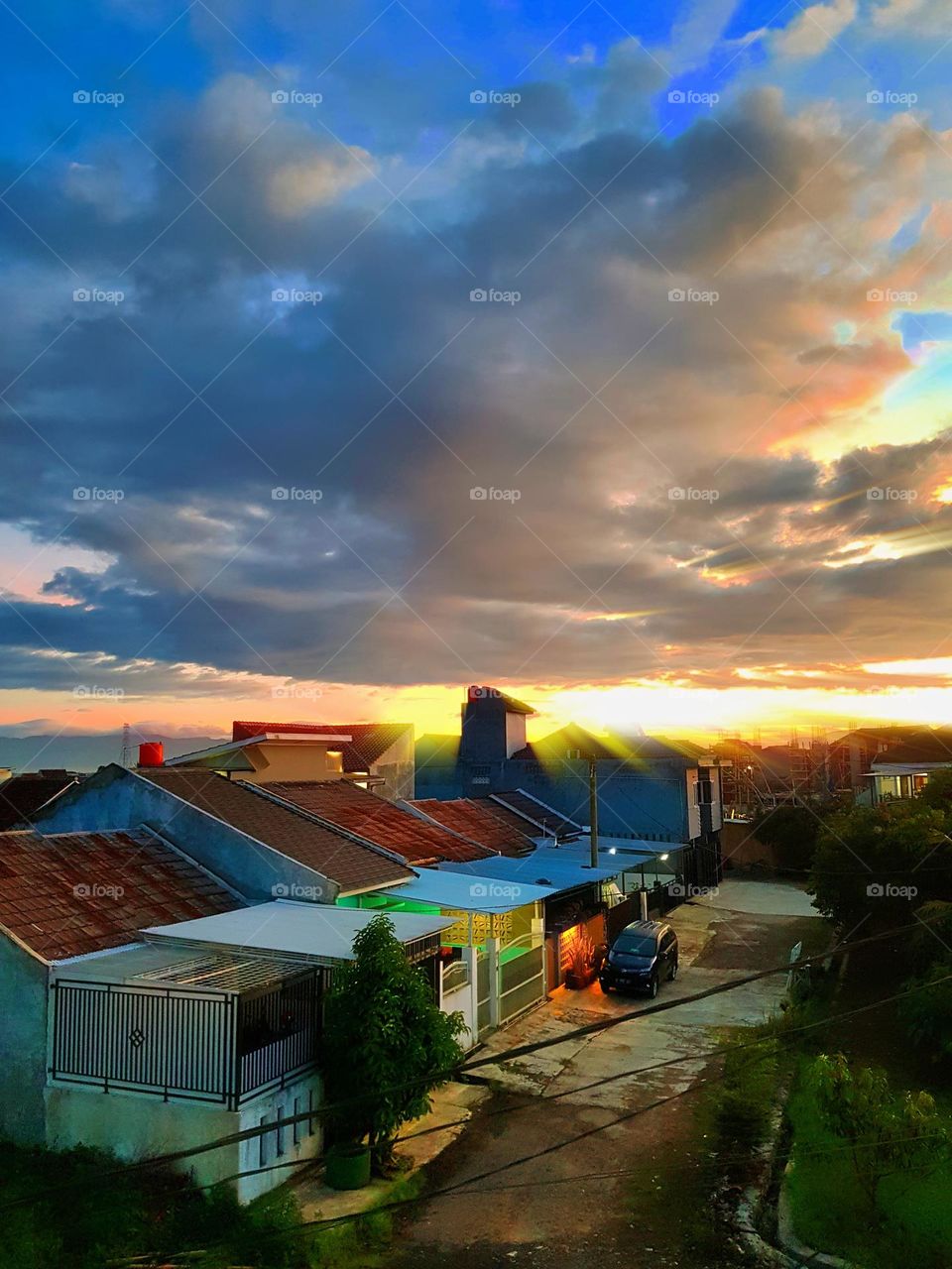 Colorful morning scenery, early morning cloud sky, early morning sun rising, sky glistening around the sun and blue above, clouds still dark,