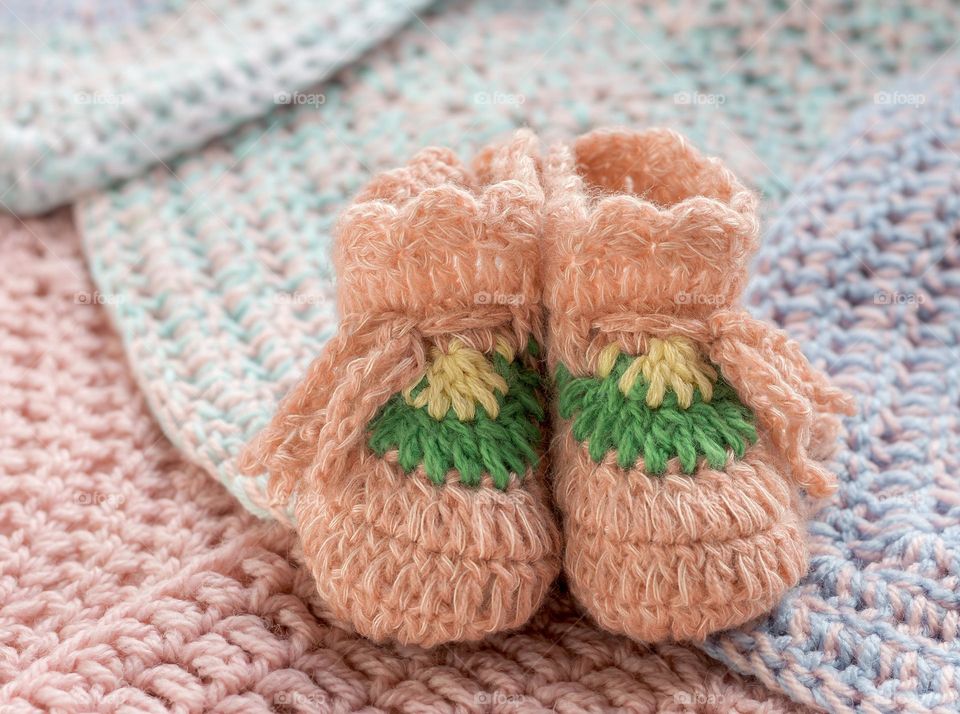 Crocheted baby booties with squares to make a blanket