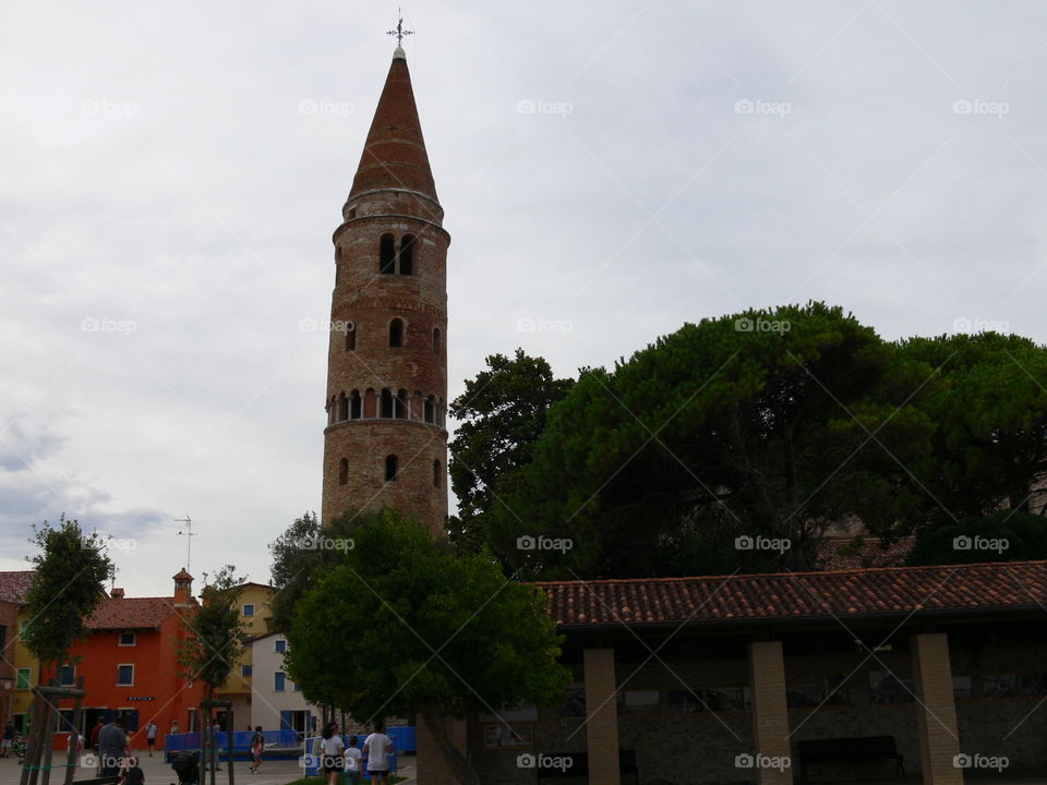 a panoramic view of caorle venice italy dome church bell tower during a cloudy day