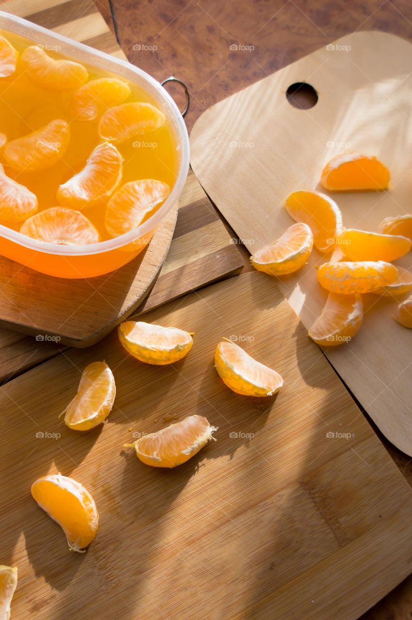 Delicious orange jelly with tangerine slices in a container and jelly worms.
