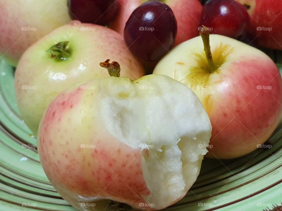 apple without a bite closeup with cherries