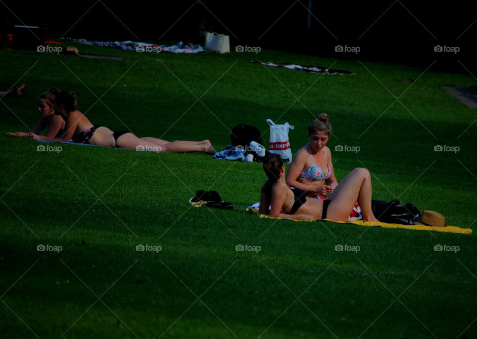 Women Sunbathe On The Grass