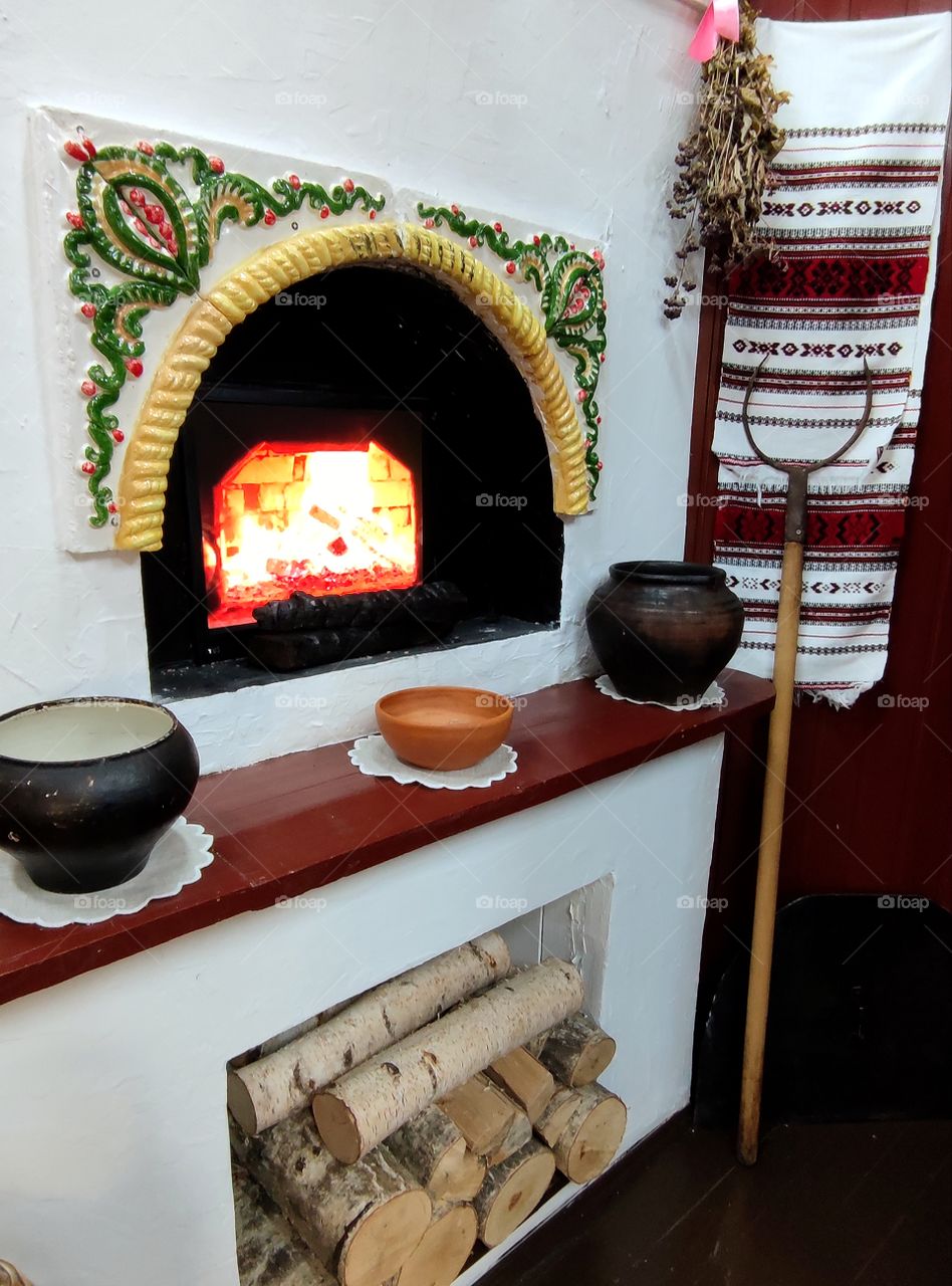 Russian stove, inside of which food was cooked in cast iron on the fire. In the lower part of the stove there is firewood for the firebox. There are cast iron on the shelf. In the corner there is a grip, with the help of which they pulled out ready