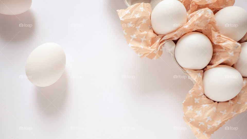 White eggs on white background on rustic paper