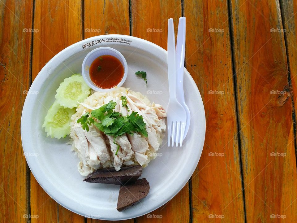 Rice with chicken on the orange table. Thai food.