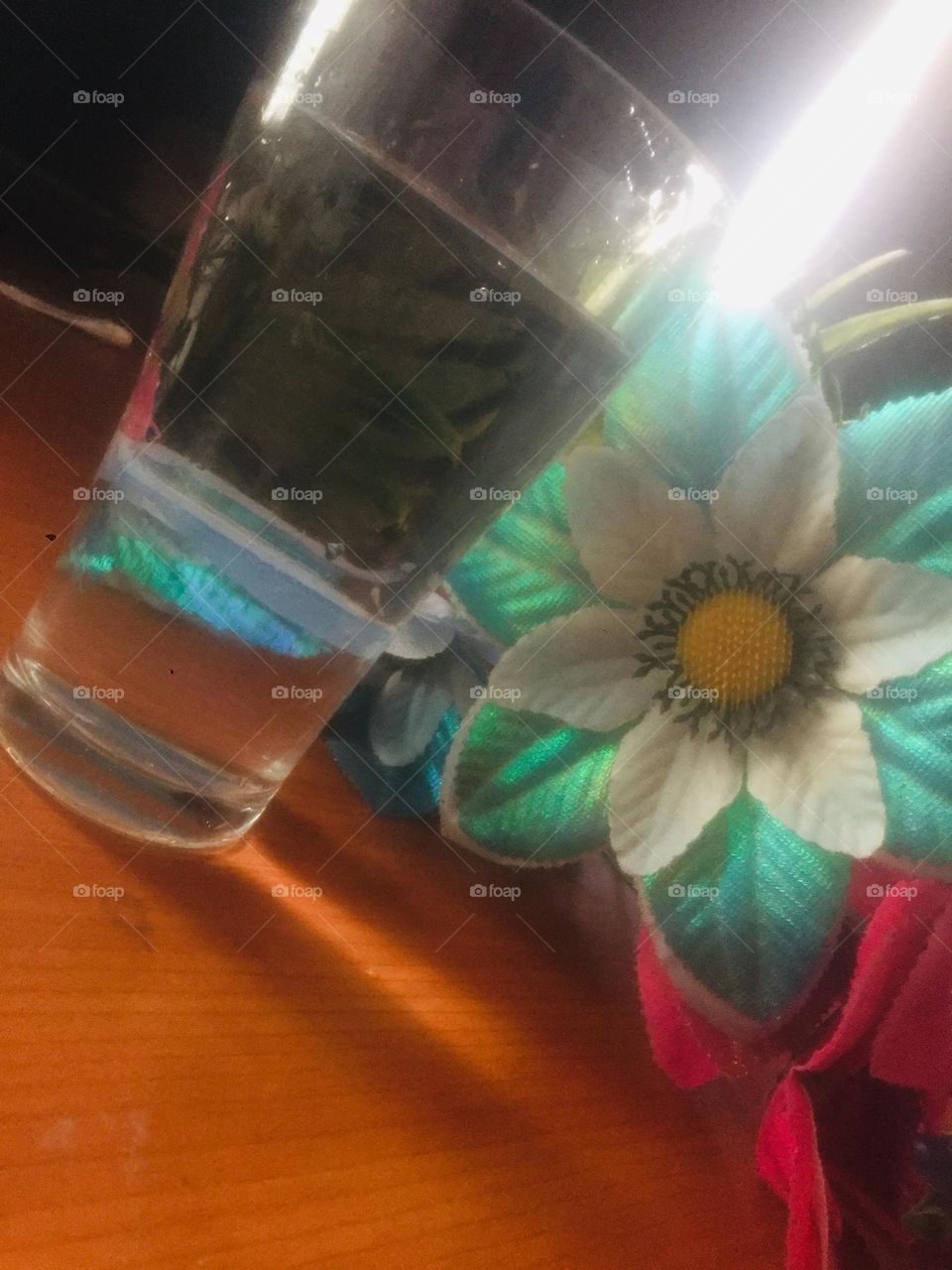 Plastic flowers and glass of water