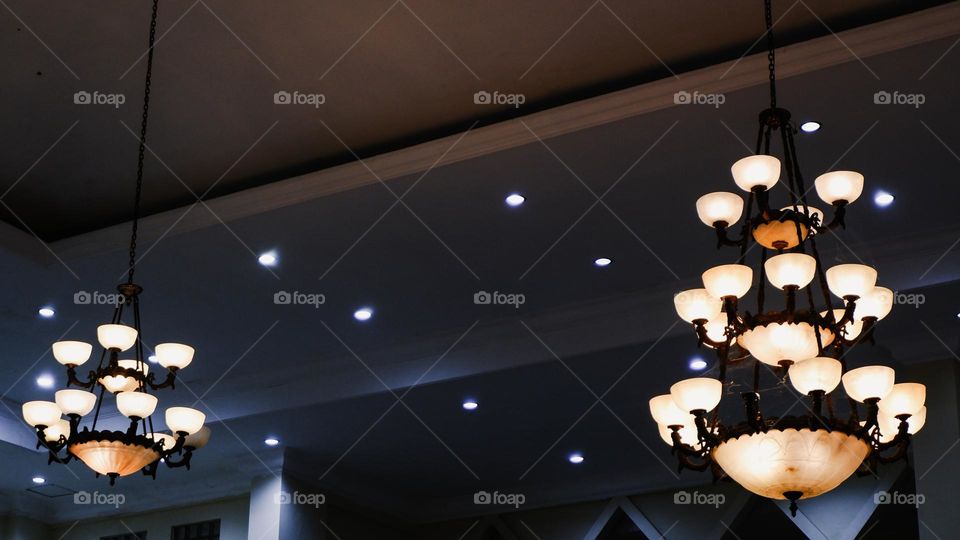 Portrait of a classic style indoor chandelier with many lights arranged upwards, the chandelier is suitable for the interior of a living room or family room.