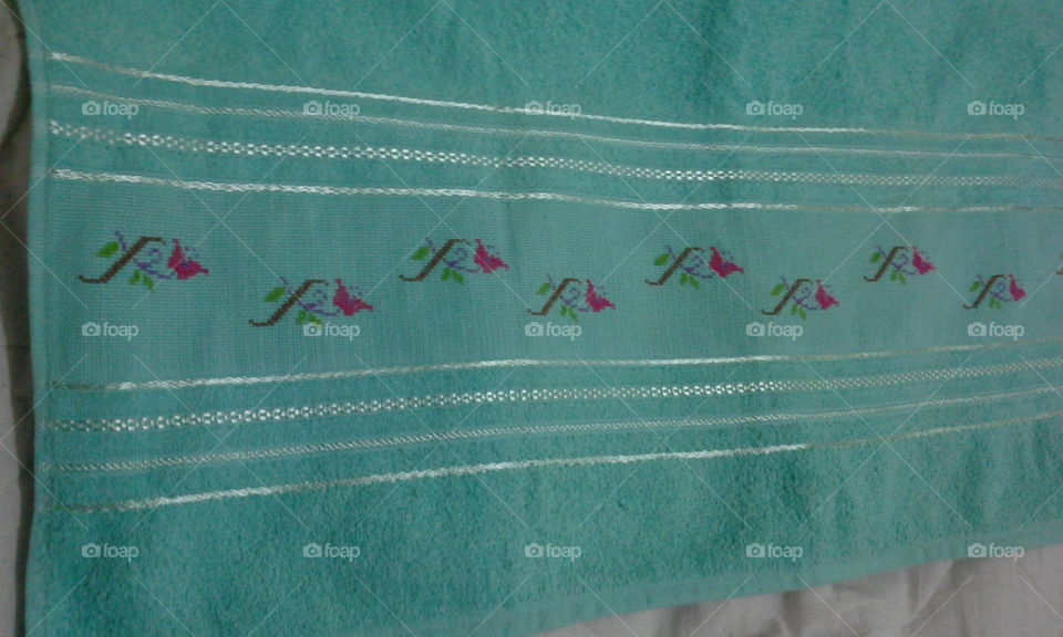handmade, embroidery with cross stitch. flowers in a shower towel.