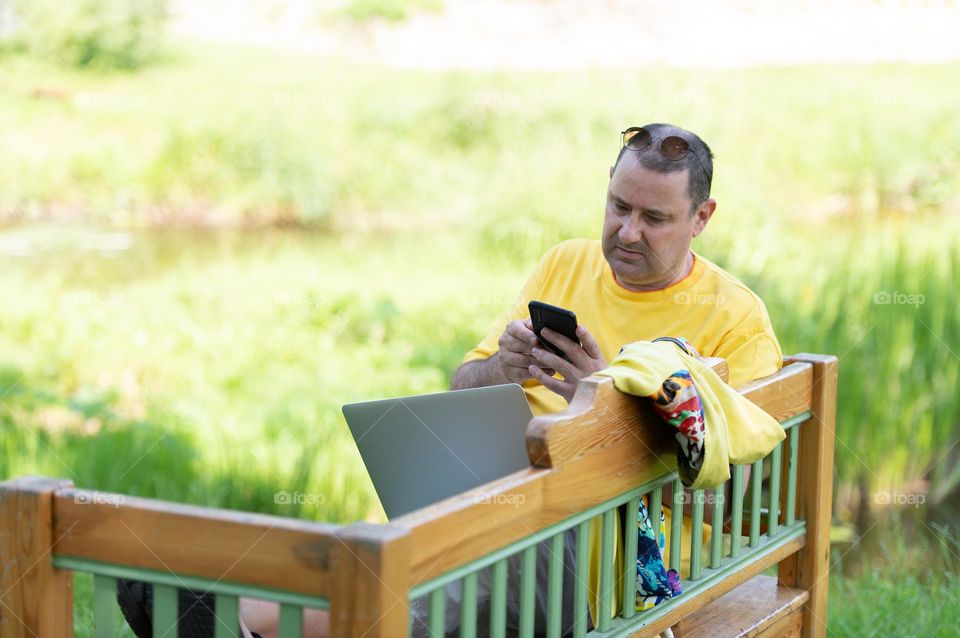 Middle-aged man using phone outdoor