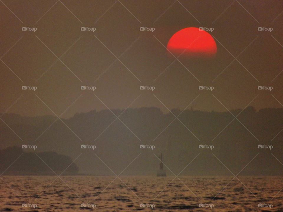 Silhouette of mountain near sea in the foggy morning