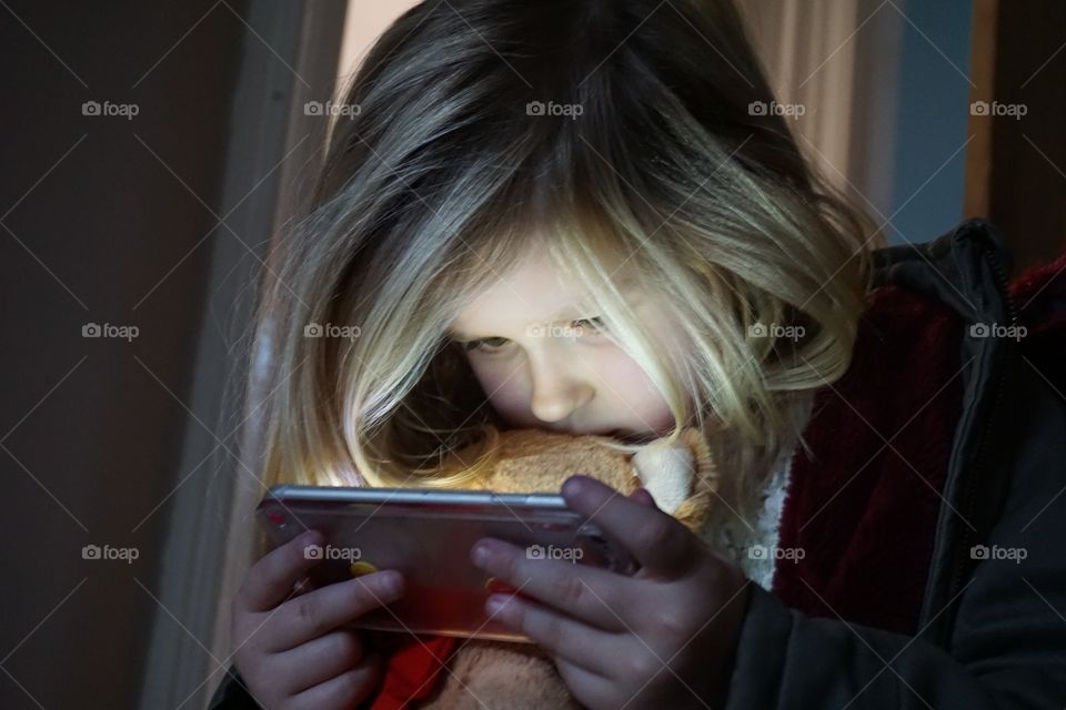 Close-up of small girl holding mobile phone in hand