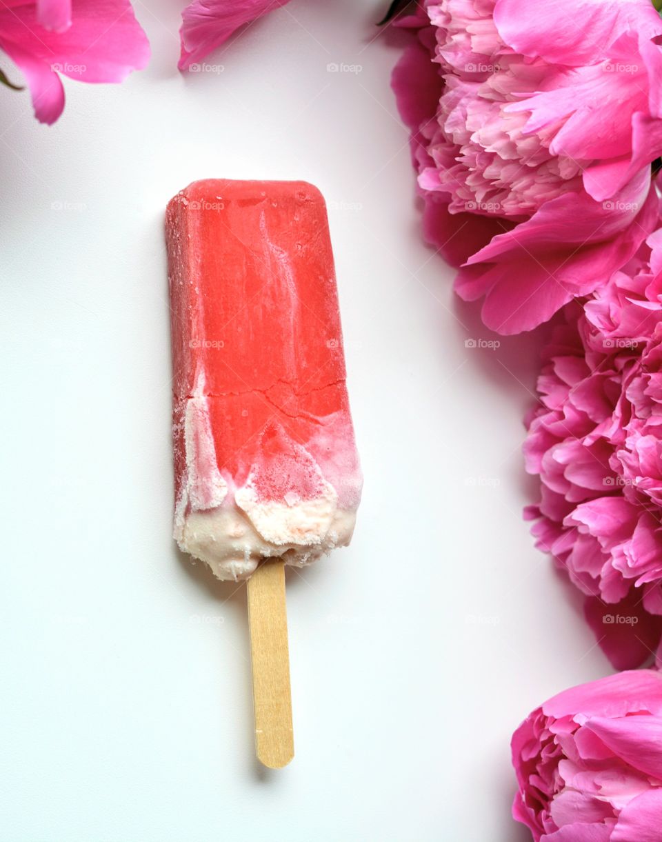 ice cream and pink piony flowers on a white background top view