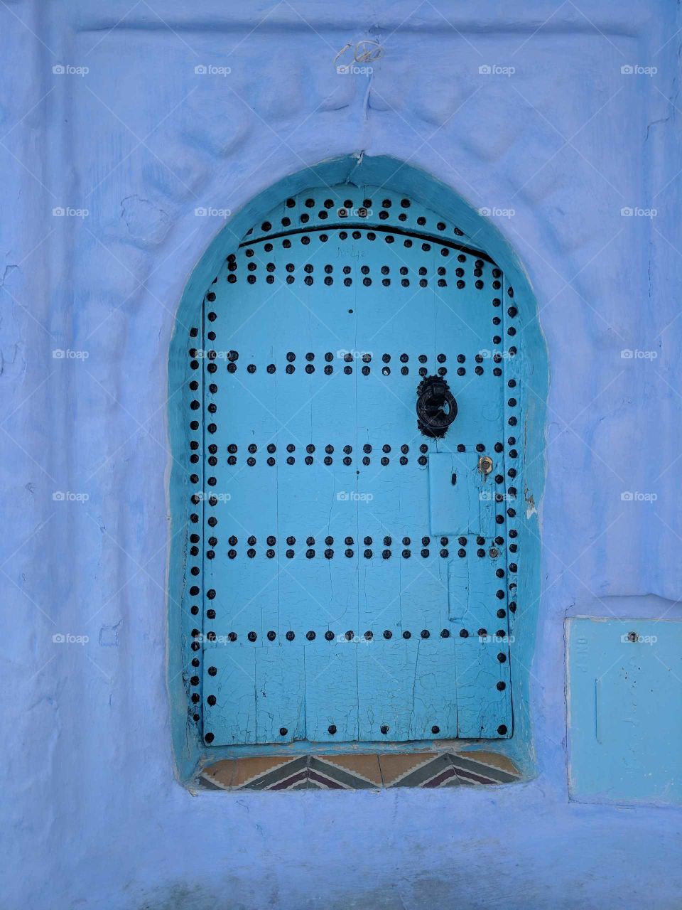 Ornate Turquoise Door Surrounded by Blue Wall in the Medina of Chefchaouen (the Blue City) in Morocco