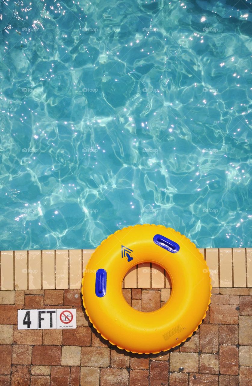 Foap mission Shapes: a round pool float sitting on the edge of a swimming pool. 